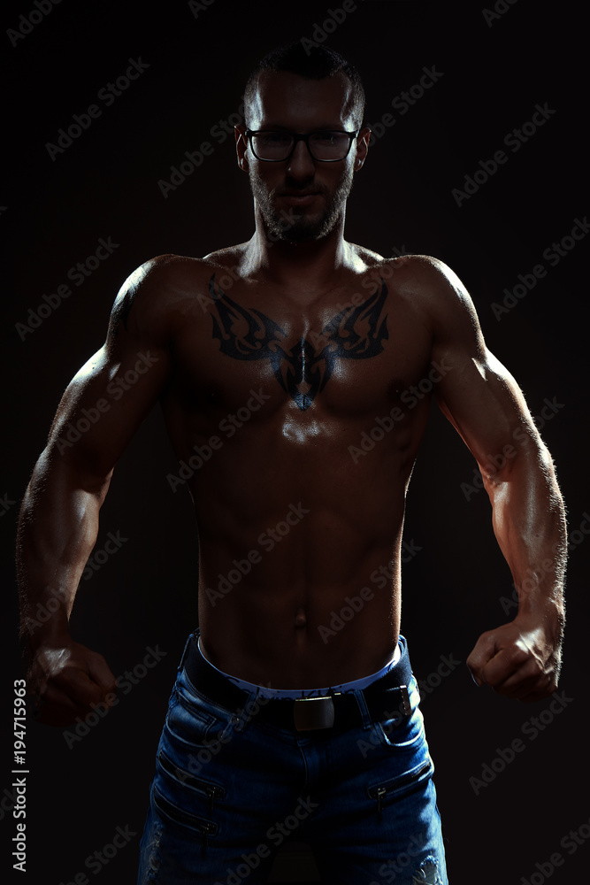 Muscular man posing in studio on dark background Muscular man posing in studio on dark background