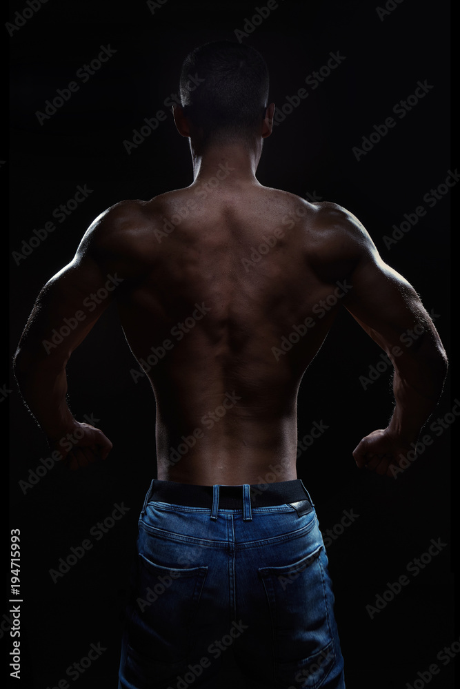 Muscular man posing in studio on dark background Muscular man posing in studio on dark background