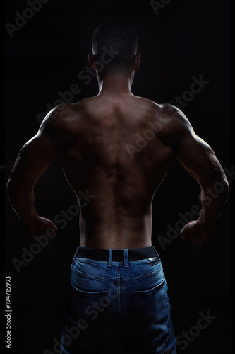 Muscular man posing in studio on dark background