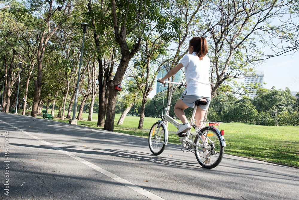 Close up young woman riding bike bicycle in the natural public park Close up young woman riding bike bicycle in the natural public park