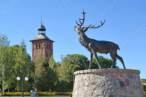 ZNAMENSK, RUSSIA. Sculpture of a deer and Saint Yakov's Lutheran church. photo