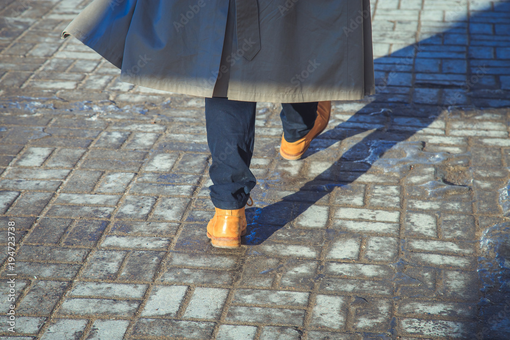 a man in yellow shoes walking along the pavement