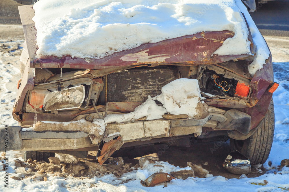 Fototapeta premium old broken car after an accident in the snow