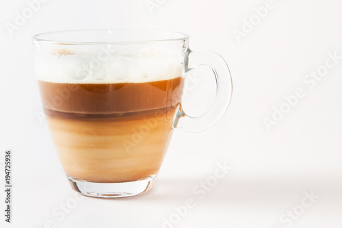 Coffee cappuccino in a transparent cup and saucer on a white background