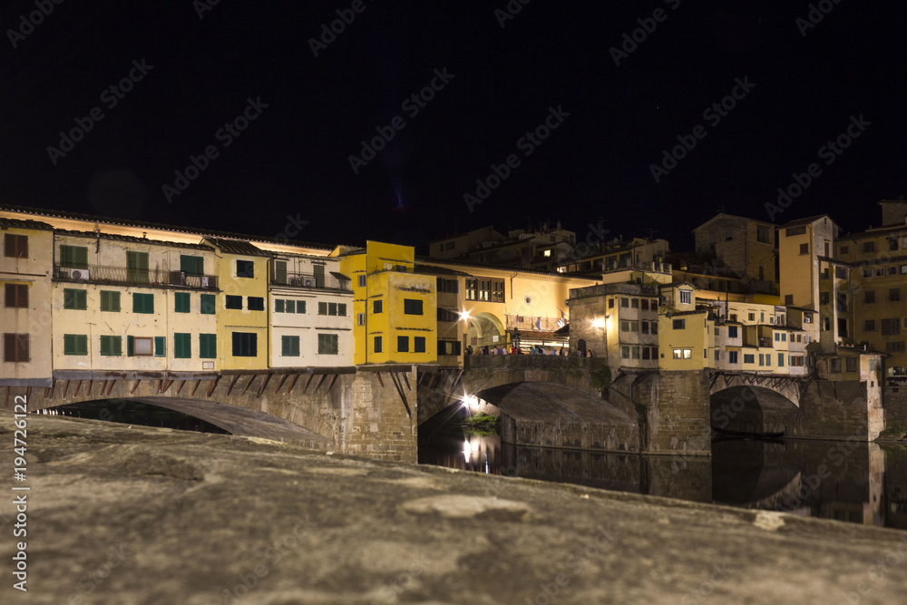Lateral view at night of historic bridge in Florence, Italy