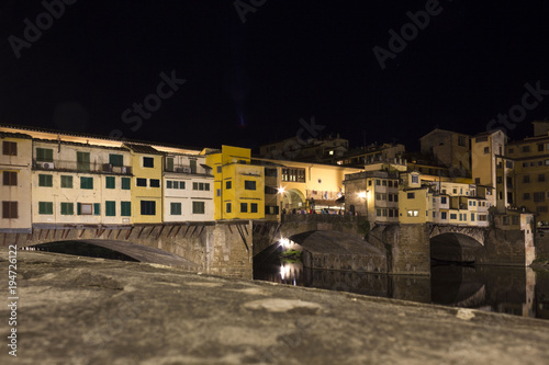 Lateral view at night of historic bridge in Florence, Italy