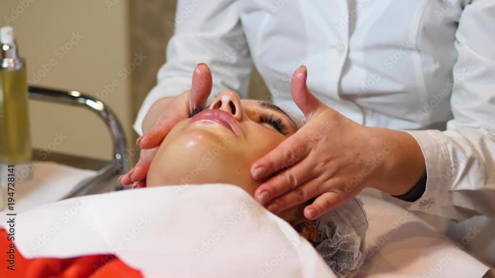 Cosmetologist is going face mask . peeling for young woman. Woman is having cosmetology procedure Cosmetologist is going face mask . peeling for young woman. Woman is having cosmetology procedure