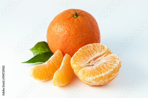 Whole tangerines or mandarines orange fruits and peeled segments isolated on white background
