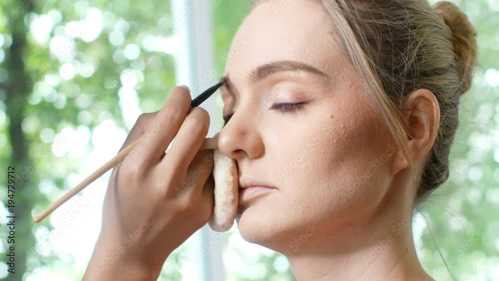 woman makeup her face at studio. Specialist doing makeup for model. woman makeup her face at studio. Specialist doing makeup for model.