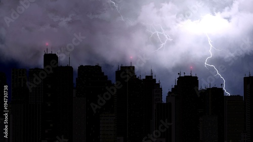 Stunning view of lightning bolts strike above city skyscrapers at night time