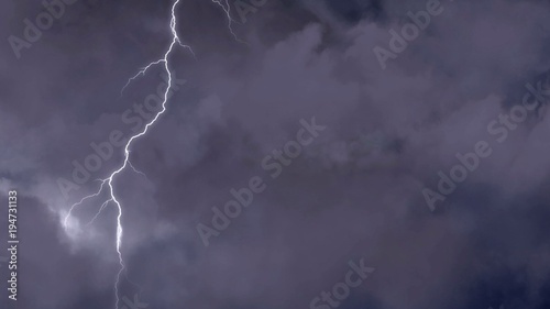 Night skyscape with lightning and thunderstorm flashing in darkness, weather