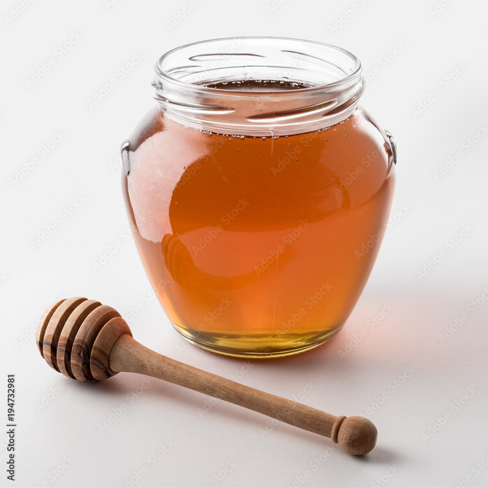 Honey dipper and honey in jar on white background. Honey dipper and honey in jar on white background.