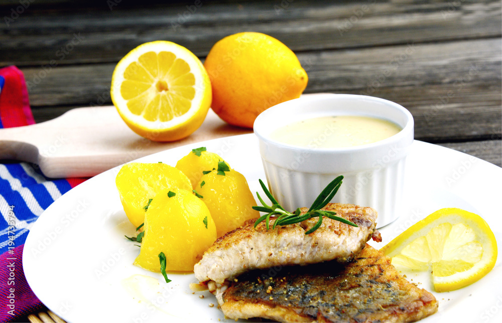 Grilled Fish with Lemon Butter Sauce and potatoes Stock Photo | Adobe Stock
