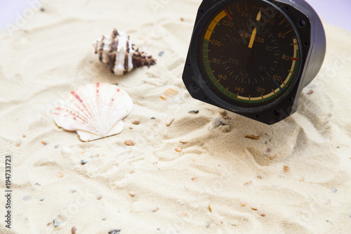 Vacation concept. White tropical sand and seashells, vintage airplane clock, top view, flat lay photo