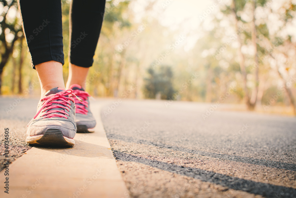 Feet woman running on the road for health, color of vintage tone selective and soft focus