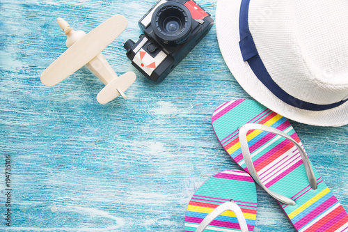 Vacation concept. Old vintage camera, a hat and beach slippers on blue wooden background