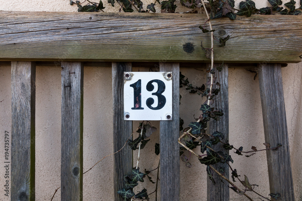 The number 13 on an old park bench. Symbol picture for Friday the 13th. Superstition.