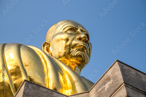 Golden face buddha statue with clear blue sky, Luang Pu Tim at Wat Lahan Rai, Rayong, Thailand