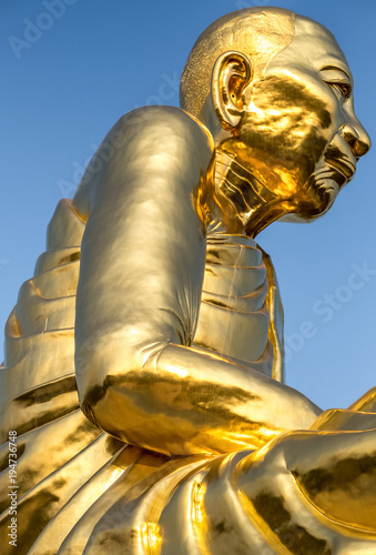 Side view Big golden buddha statue with clear blue sky, Luang Pu Tim at Wat Lahan Rai, Rayong, Thailand