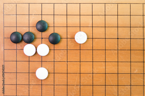 Game's white and black stone on cross board.