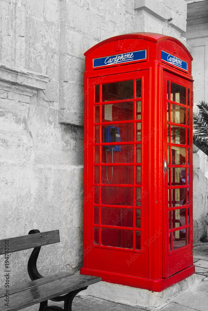 Obraz premium An iconic red telephone box in maltese town Mdina. Malta English language school education concept. Black, white and color mixed toned gift card.