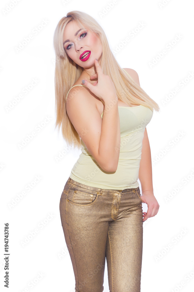 Studio portrait of a beautiful young blond woman with long hair, dressed in a summer yellow jersey and golden jeans. Concept: summer mood. Isolate. Copy space Studio portrait of a beautiful young blond woman with long hair, dressed in a summer yellow jersey and golden jeans. Concept: summer mood. Isolate. Copy space