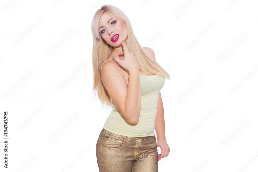 Studio portrait of a beautiful young blond woman with long hair, dressed in a summer yellow jersey and golden jeans. Concept: summer mood. Isolate. Copy space Studio portrait of a beautiful young blond woman with long hair, dressed in a summer yellow jersey and golden jeans. Concept: summer mood. Isolate. Copy space