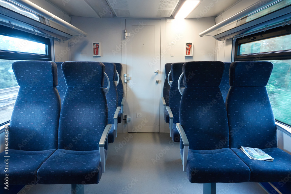 Naklejka premium Salon of a modern train without people. On the armchair lies the news paper