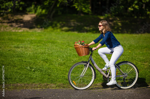 Fototapeta Naklejka Na Ścianę i Meble -  Urban biking - woman riding bike in city park