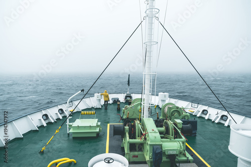 Rear view of man looking at view while standing on ship's bow