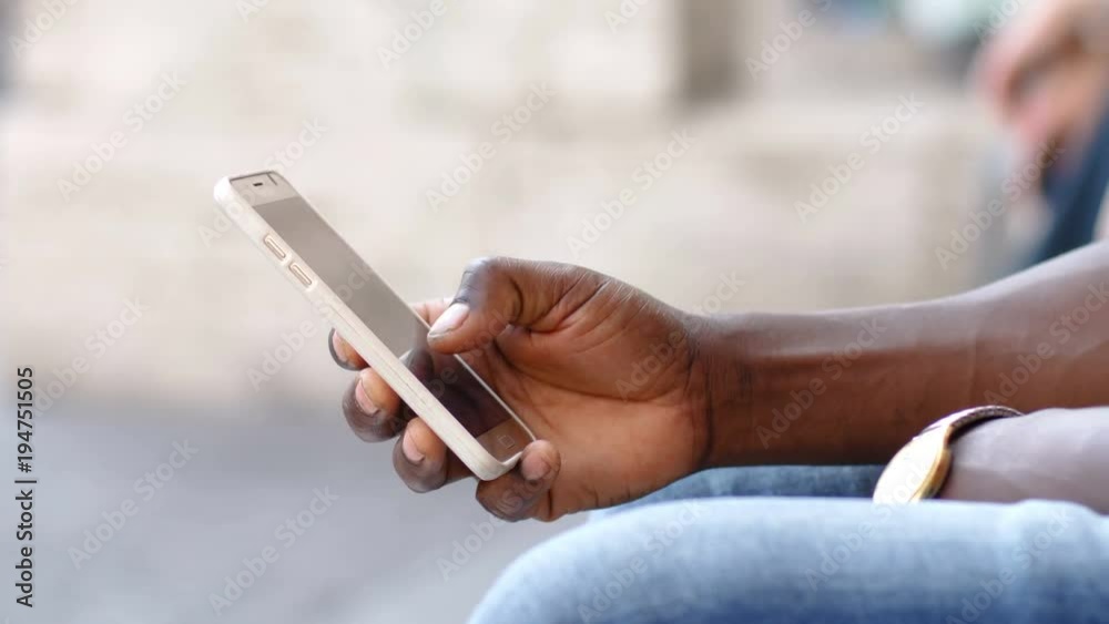 hand of black man typing on the smartphone- outdoor