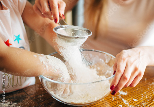 Obraz na płótnie Mother and child sieving flour
