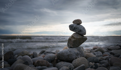 Photography Photo of the pyramid of the stones on ocean background.