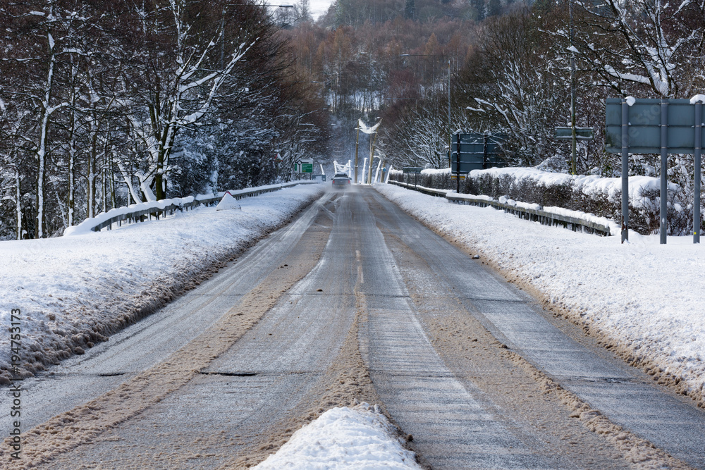 snow slowly clearing from the road as more cars begin to use it snow slowly clearing from the road as more cars begin to use it