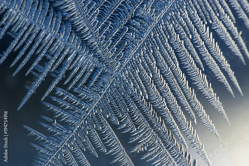 Frosted window. Pattern of ice chrystals on a glass surface. Macro shot.