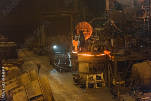 Melting of metal in a steel plant. High temperature in the melting furnace. Metallurgical industry. Factory for the manufacture of metal pipes. Bucket for feeding metal into molds. © davit85