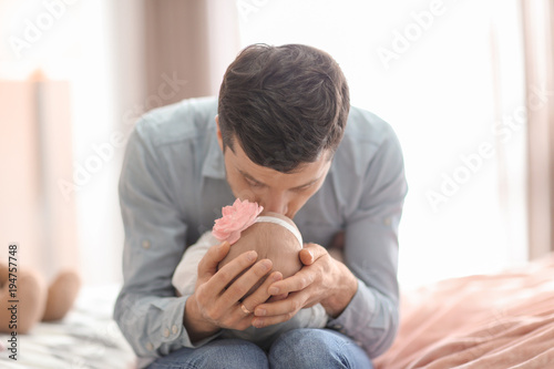 Young father with his cute little baby at home