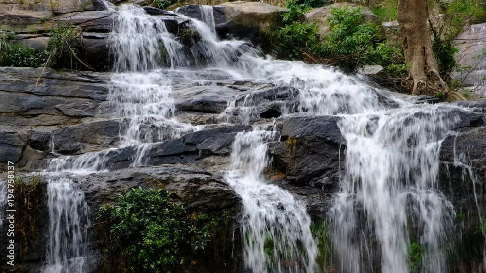 Close up.Pure fresh water waterfall in forest with black rocks. Close up.Pure fresh water waterfall in forest with black rocks.