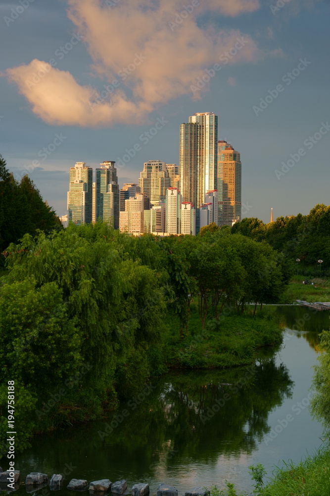 Cityscape of Seoul, South Korea, with high-rise apartment buildings in the evening sun and a park in the foreground Cityscape of Seoul, South Korea, with high-rise apartment buildings in the evening sun and a park in the foreground