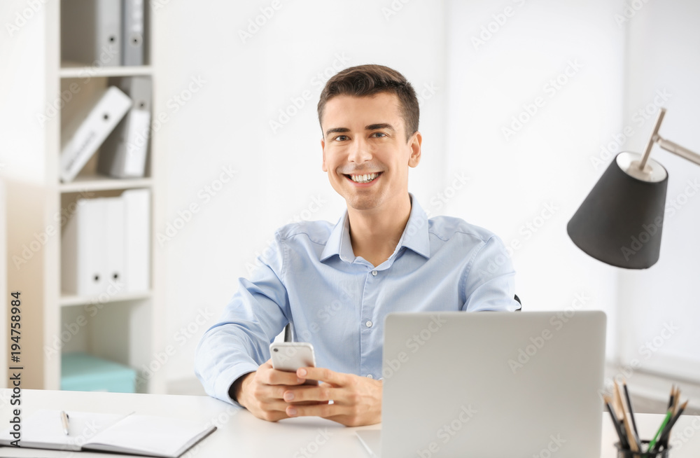Young man using phone at table indoors Young man using phone at table indoors