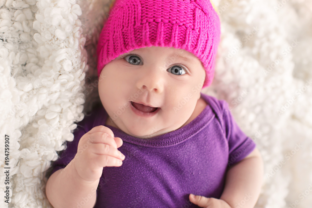 Little baby in cute hat lying on plaid Little baby in cute hat lying on plaid