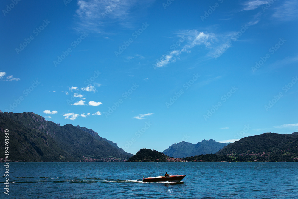 Amazing view of bright blue Como lake, Lombardy Italy, panorama of the lake and the city. Mountains on the background and good sunny summer weather