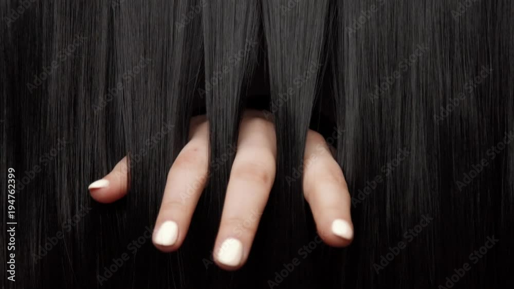 Hair texture background, no person. Black shiny hair Hands touching it