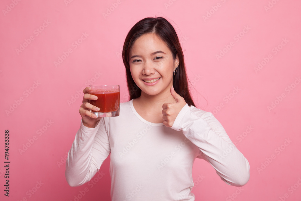 Young Asian woman thumbs up with tomato juice. Young Asian woman thumbs up with tomato juice.