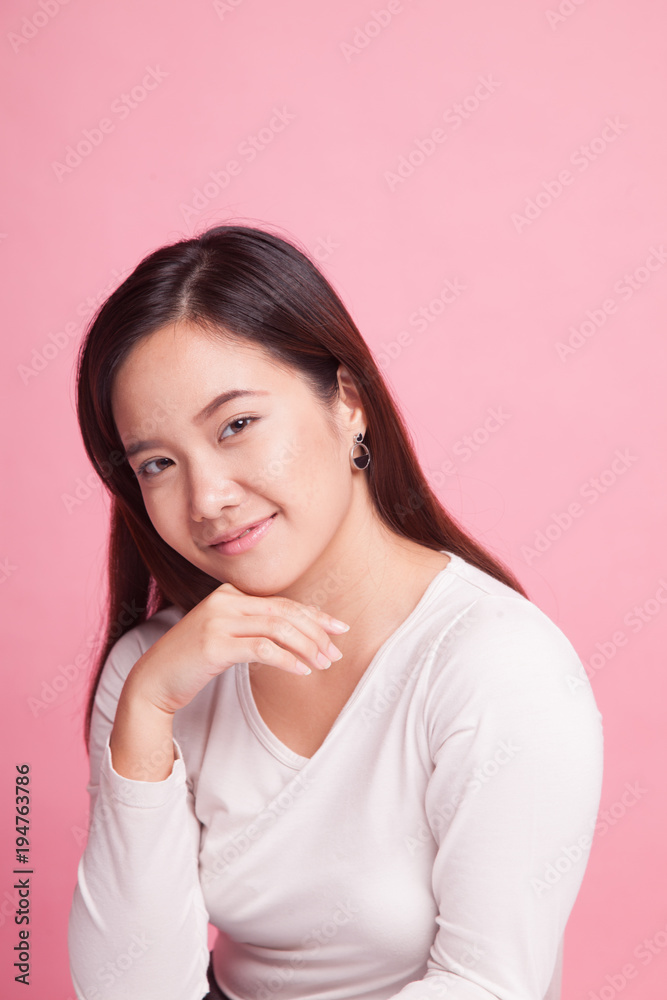 Beautiful young Asian woman smiling on pink background Beautiful young Asian woman smiling on pink background