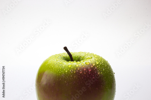 A red and green apple with water drops isolated on a white background.