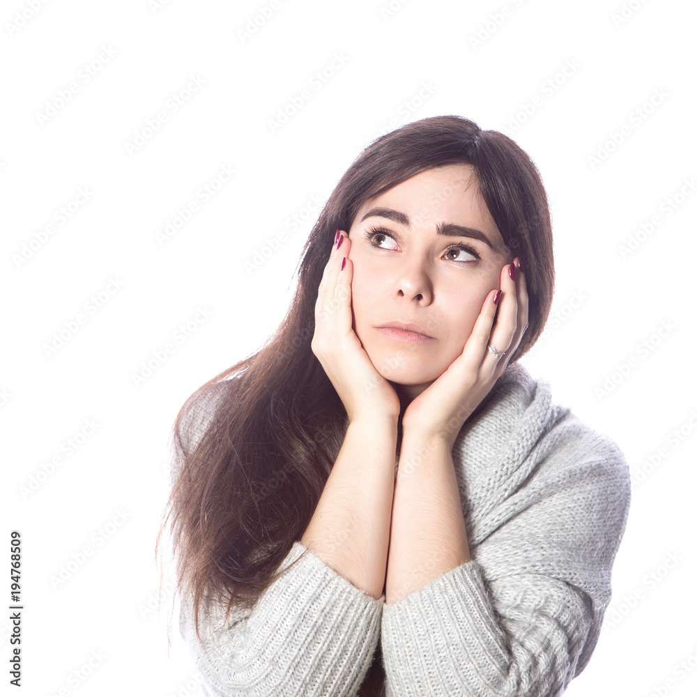 Cute teenage girl with long dark hair standing on a white background in grey oversize sweater. Emotional lifestyle portrait Cute teenage girl with long dark hair standing on a white background in grey oversize sweater. Emotional lifestyle portrait
