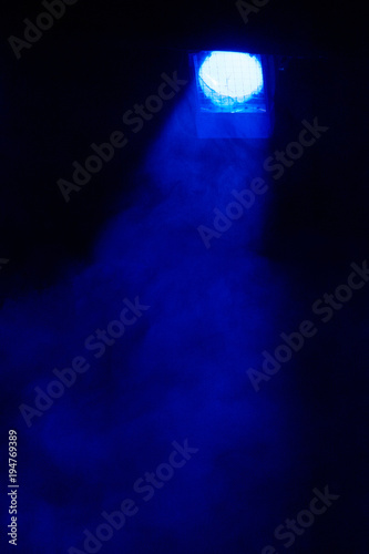 Theatrical light. Blue spotlight. A ray of light in the dark. Above the stage. Place for text.