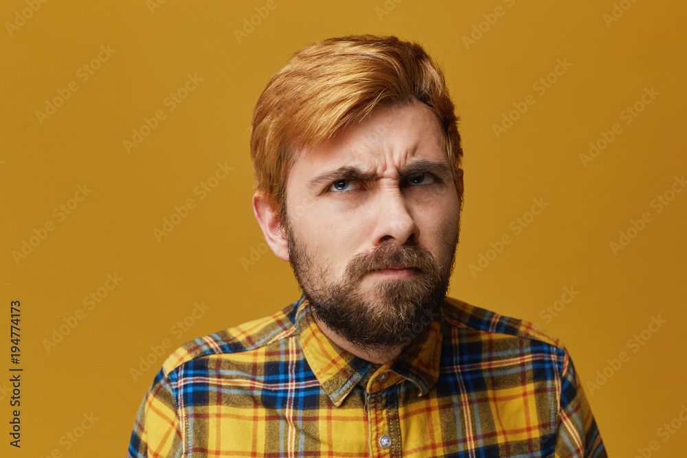 Puzzled serious thinking man, with beard and mustache has angry expression, look up and have no idea how solce the problem. Isolated over yellow background. Puzzled serious thinking man, with beard and mustache has angry expression, look up and have no idea how solce the problem. Isolated over yellow background.