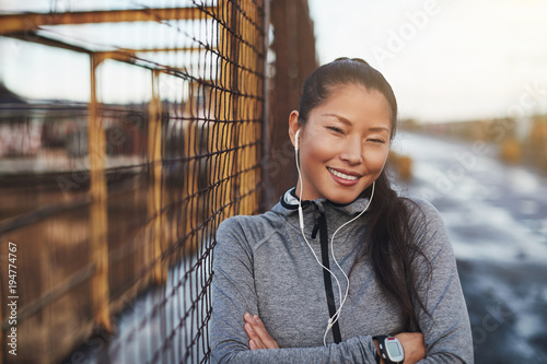 Young Asian woman in sportswear listening to music before joggin photo